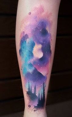 a woman's leg with a watercolor painting on it and trees in the background