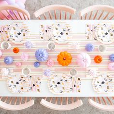 an overhead view of a table with plates and napkins on it, decorated with pastel colors