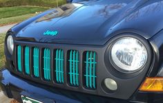 the front end of a black jeep with green grills on it's grille