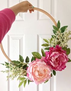 a person holding a hoop with flowers on it