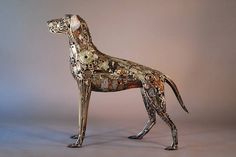 a metal sculpture of a dog standing in the middle of it's legs and body