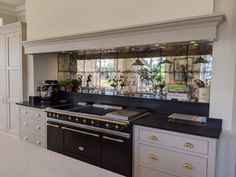 a large kitchen with white cabinets and black counter tops, along with an island in the middle