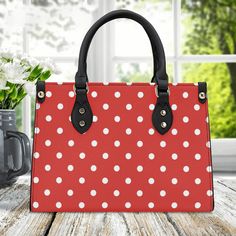 Discover the latest in handbag fashion with our collection. This Red Polka-Dot Handbag - is a playful and chic accessory that effortlessly combines classic style with a modern twist. The bold red hue adds a touch of vibrancy to your ensemble, while the whimsical white polka dots infuse a sense of timeless charm. Crafted with meticulous attention to detail, this handbag is not only a fashion statement but also a versatile companion for any occasion. Elevate your look with this eye-catching access Retro Red Bags With Handles, Red Bags With Gold-tone Hardware For Shopping, Red Bags With Silver-tone Hardware, Polka Dot Tote Bag, Red Shoulder Bag With Silver-tone Hardware And Double Handle, Red Purse, Leather Handbags Women, Printed Handbags, Shoulder Strap Bag