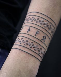 a man with a tattoo on his arm that has an egyptian pattern and the words