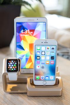 two cell phones and an apple watch on a table