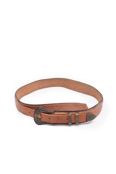 This vintage 90s Western-style belt is made from rich brown leather and features a beautifully embossed brass metal buckle. The intricate detailing on the buckle reflects classic Western craftsmanship, adding a rustic charm to the belt. Its durable leather and sturdy brass accents make it both functional and stylish, perfect for pairing with jeans or dresses. This belt is ideal for those looking to add a touch of vintage Western flair to their wardrobe with a timeless, rugged accessory. - Label: no label  - Color: brown and brass  - Fabric: metal, real leather  - Condition: very good. Ready to wear. MEASUREMENTS: Length: 33" (85 cm) at longest length / 29.3" (75 cm) at shortest length  Width:  1.5" (4 cm) 90s Western, Western Brown, Brown Leather Belt, Brass Accents, Suspender Belt, Vintage Western, Brass Metal, Western Style, Metal Buckles