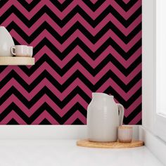 a pink and black zigzag pattern wallpaper in a kitchen with two white vases