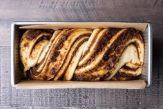 a loaf of cinnamon swirl bread in a box on a wooden table, top view