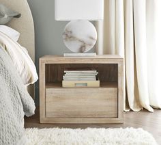 a nightstand with books and a lamp on it