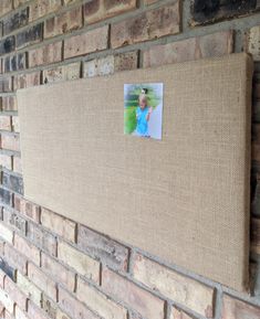 a brick wall with a photo pinned to it