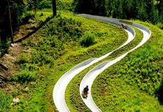 two people riding motorcycles down a curvy road