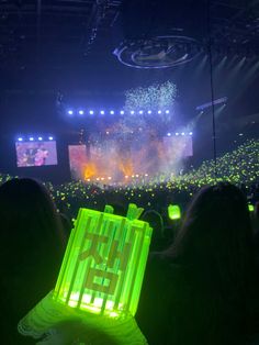 people are watching fireworks in the dark at a concert with green lights on their head