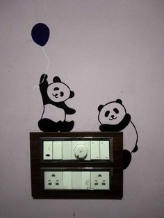 two pandas are sitting on top of a radio and one is holding a balloon