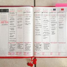 an open planner with red push pins on the pages and numbers in each page,