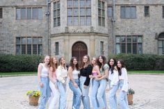 a group of young women standing in front of a large building