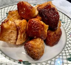 a plate topped with pastries on top of a white and green tablecloth covered table