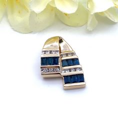 This beautiful channel set blue sapphire and natural diamonds 14k yellow gold pendant slide can fit on a regular or omega chain. Chain is NOT included  Pendant Measurements Length:  11/16" (18mm) Width:  9/16" (14mm) Bail opening: mm Gemstones: 9 Straight Baguette Blue Sapphires Carats: .90 ctw Diamonds: 10 Round Brilliant Cut Natural Diamonds Carat: .10 ctw Clarity: I1 Color: G/H Weight: 2.91 Grams Stamps: 14k THL Condition:  Excellent Pre-Owned  Items will ship in a gift box or pouch Each piece is thoroughly examined and refinished as needed by our professional jewelers, tested to guarantee metal content,  graded by our in-house GIA (Gemological Institute of America) Graduate Gemologist, and inspected for quality before being carefully packaged and promptly shipped. Thank you for taking Blue Baguette Diamond Jewelry For Anniversary, Sapphire Jewelry With Channel Set For Anniversary, Sapphire Jewelry With Channel Set And Round Cut, Gift Jewelry With Sapphire And Baguette Diamonds, Yellow Gold Sapphire Jewelry With Baguette Diamonds, Sapphire Jewelry With Baguette Diamonds As A Gift, Sapphire Jewelry With Baguette Diamonds For Gift, Blue Sapphire Channel Set Jewelry, Gold Sapphire Jewelry With Channel Set