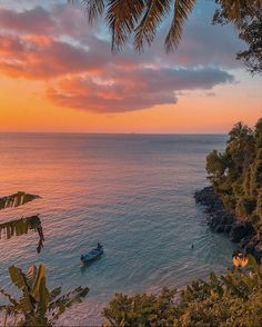 the sun is setting over the ocean with boats in the water and palm trees on the shore