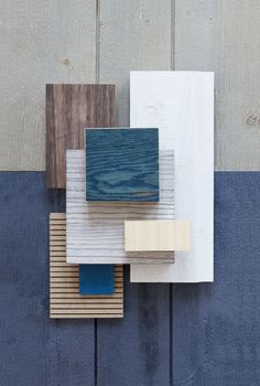 three different colored wood pieces on a wall with blue and white paint in the background