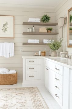 a white bathroom with open shelving and towels on the shelf above the sink area