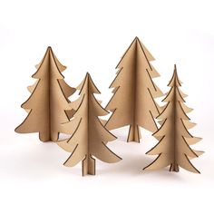 three cardboard christmas trees sitting next to each other on a white surface with one cut out in the shape of a tree