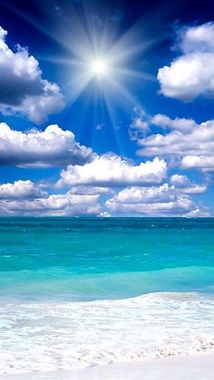 the sun shines brightly over the ocean on a sunny day with blue skies and white clouds