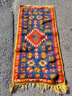 an old rug is laying on the ground next to some concrete and cement flooring