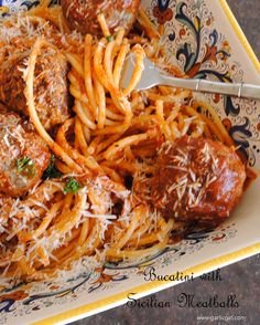 spaghetti with meatballs and parmesan cheese on a plate