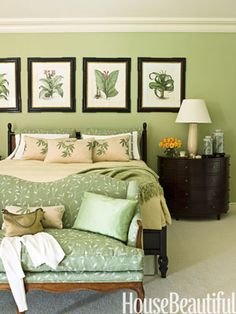 a bedroom with green walls and pictures on the wall