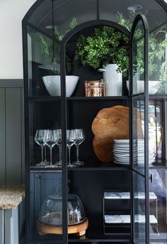 a glass cabinet with plates and glasses in it