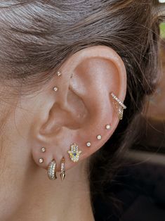 a close up of a person's ear with three different piercings on it