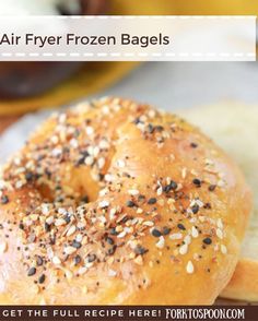 an air fryer frozen bagel with sesame seeds on it and other foods in the background