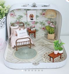 a dollhouse bedroom is shown with pink flowers on the wall and white bedding