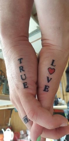 two people holding hands with tattoos on their fingers that say i love you and true love