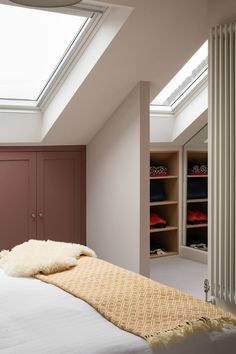 a bedroom with a bed, closet and skylight in the ceiling is shown here