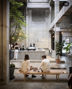 two people sitting on a bench in an office building