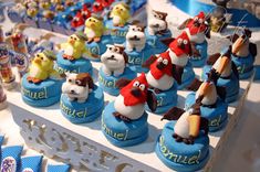 a table topped with lots of cupcakes covered in frosting and fondant