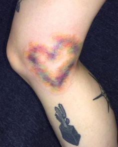 a person with tattoos on their legs has a heart shaped kite in the shape of a hand