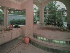 a bathroom with two sinks, tub and large windows in it's center area