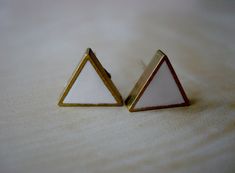 Here's the answer to your search for a great pair of everyday studs. Each pair of small brass triangle stud earrings is filled with polymer clay, with a multitude of colours available.This listing is for a pair of matte finish ivory triangle studs.Studs measure 10 millimeters in diameter and 2.5 millimeters thick. Brass hexagon forms are filled and filed, and then adhered to 18 karat gold-plate bases with tight-fitting butterfly backings.Check my other listings for additional colour selections!! Ceramic Beads Necklace, Triangle Stud Earrings, Triangle Earrings Stud, Triangle Studs, Geometric Studs, Black Sparkle, Triangle Earrings, Ceramic Beads, Etsy Earrings