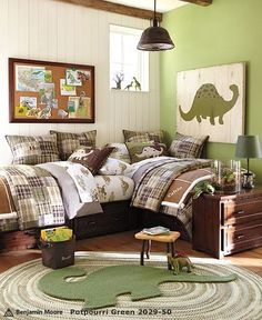 a bed room with a neatly made bed and dinosaur themed comforters on it's covers