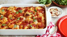 a casserole dish with meat and cheese in it on a table next to other dishes