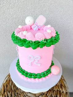 a pink and green cake sitting on top of a wicker basket