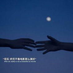 two hands reaching towards each other with the moon in the background