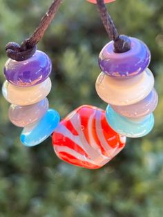 colorful glass beads hanging from a tree branch