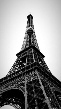 the eiffel tower in black and white is seen from below, looking up