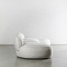 a white couch sitting on top of a cement floor