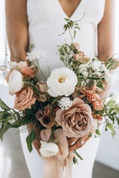 a bride holding a bouquet of flowers in her hands