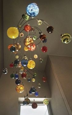 a multicolored glass ball chandelier hanging from the ceiling in a room