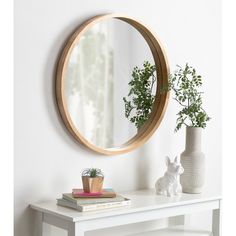 a white table with a mirror and some plants